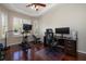 This work from home space has hardwood floors, a tray ceiling and a window with white shutters at 14809 Tudor Chase Dr, Tampa, FL 33626