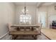 Formal dining room features rustic wood table and bench, elegant seating, and modern chandelier at 14809 Tudor Chase Dr, Tampa, FL 33626