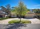 Charming home featuring a red front door, stone accents, lush landscaping, and a paver driveway at 14809 Tudor Chase Dr, Tampa, FL 33626
