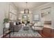 Bright living room featuring hardwood floors, a modern chandelier, and views of the backyard at 14809 Tudor Chase Dr, Tampa, FL 33626