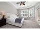 Bright main bedroom with tray ceiling, large windows, and plush carpet at 14809 Tudor Chase Dr, Tampa, FL 33626