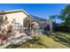 Screened-in pool area in the backyard, complete with a grassy lawn and view of trees at 14809 Tudor Chase Dr, Tampa, FL 33626