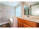 Bathroom featuring a glass block window, a tub, and wood vanity at 16012 Ballica Dr, Tampa, FL 33618