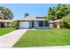 Charming single-story home with a well-maintained lawn and a screened porch at 16012 Ballica Dr, Tampa, FL 33618