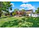 Serene backyard showcasing a screened lanai and lush, mature landscaping for privacy at 17108 Longacres Ln, Odessa, FL 33556