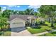 Well-maintained home featuring manicured lawn, mature trees, and a two-car garage at 17108 Longacres Ln, Odessa, FL 33556