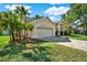 Charming single-Gathering home with a two-car garage and a well-manicured lawn with tropical plants at 17108 Longacres Ln, Odessa, FL 33556