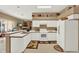 Well-lit kitchen features white appliances, ample counter space, and an adjacent dining area at 17108 Longacres Ln, Odessa, FL 33556