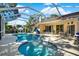 Relaxing screened pool area complete with a spa, outdoor furniture, and lush landscaping at 17108 Longacres Ln, Odessa, FL 33556