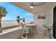 Inviting balcony with chairs and tables overlooks a beautiful sandy beach at 17940 Gulf Blvd # 2D, Redington Shores, FL 33708