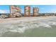 View of the sandy beach and ocean waves in front of three high-rise condo buildings at 17940 Gulf Blvd # 2D, Redington Shores, FL 33708