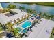 High-angle view of pool, lush greenery, dock, and waterfront scenery at 19417 Gulf Blvd # B-210, Indian Shores, FL 33785