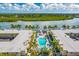 Panoramic aerial showcases an inviting pool, lush landscaping, and waterfront views at 19417 Gulf Blvd # B-210, Indian Shores, FL 33785