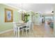Dining area showcasing a table with seating, a modern chandelier, and a glimpse into the living room at 19417 Gulf Blvd # B-210, Indian Shores, FL 33785