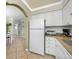 View of the kitchen area with granite countertops, white cabinets and appliances at 19417 Gulf Blvd # B-210, Indian Shores, FL 33785