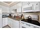 Bright kitchen featuring white appliances, tile backsplash, and ample counter space at 19417 Gulf Blvd # B-210, Indian Shores, FL 33785