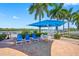 Waterfront patio area with umbrella, table, chairs, and lounges, perfect for outdoor relaxation at 19417 Gulf Blvd # B-210, Indian Shores, FL 33785