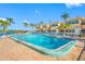 Community pool with lounge chairs surrounded by tropical landscaping and blue skies at 19417 Gulf Blvd # B-210, Indian Shores, FL 33785