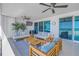 Relaxing outdoor seating with sofas and chairs showcasing ocean views on a spacious, sunny balcony at 19816 Gulf Boulevard # 201, Indian Shores, FL 33785