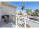 Balcony with glass railings overlooking tropical palms and a neighborhood intersection at 19816 Gulf Boulevard # 201, Indian Shores, FL 33785
