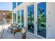 Balcony with seating area and glass railings offering views of nearby tropical palms at 19816 Gulf Boulevard # 201, Indian Shores, FL 33785