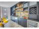 Custom wet bar with glass shelving, wine coolers, a mirrored backsplash, custom cabinetry, and ample storage at 19816 Gulf Boulevard # 201, Indian Shores, FL 33785