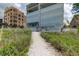 Path to the beach lined with beach grass, leading to a condo building with balconies at 19816 Gulf Boulevard # 201, Indian Shores, FL 33785