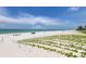 Expansive white sandy beach with green vegetation leading to the ocean at 19816 Gulf Boulevard # 201, Indian Shores, FL 33785