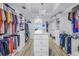 Bright walk-in closet with custom shelving, drawers, center island with a marble countertop, and chandelier at 19816 Gulf Boulevard # 201, Indian Shores, FL 33785