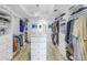 Spacious walk-in closet featuring custom shelving, drawers, and a chandelier hanging above the center island at 19816 Gulf Boulevard # 201, Indian Shores, FL 33785
