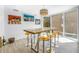 Bright dining area features a wooden table with seating, modern chandelier, and contemporary artwork at 19816 Gulf Boulevard # 201, Indian Shores, FL 33785
