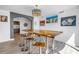 Modern dining area with unique chandelier, statement art, seating at a wooden table, and access to additional rooms at 19816 Gulf Boulevard # 201, Indian Shores, FL 33785