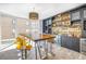 Open concept dining room with wet bar, custom lighting, a large wooden table with chrome stools, and beach views at 19816 Gulf Boulevard # 201, Indian Shores, FL 33785