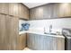 Laundry room featuring natural wood cabinets, quartz countertops, and nautical decor at 19816 Gulf Boulevard # 201, Indian Shores, FL 33785