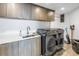 Contemporary laundry room features modern appliances, white quartz countertops, and natural wood cabinets at 19816 Gulf Boulevard # 201, Indian Shores, FL 33785