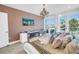 Comfortable bedroom features a chandelier, stylish furnishings and access to a balcony through sliding glass doors at 19816 Gulf Boulevard # 201, Indian Shores, FL 33785