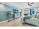 A well-decorated bedroom featuring a flat-screen TV, large windows, and access to a balcony at 19816 Gulf Boulevard # 201, Indian Shores, FL 33785