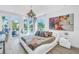 Bright bedroom features a modern bed, contemporary chandelier and access to a balcony through sliding glass doors at 19816 Gulf Boulevard # 201, Indian Shores, FL 33785