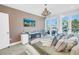 Comfortable bedroom features a chandelier, stylish furnishings and access to a balcony through sliding glass doors at 19816 Gulf Boulevard # 201, Indian Shores, FL 33785