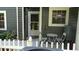 Exterior view of front door entrance with white trim and neutral paint scheme with small patio seating area at 2101 Fox Chase Blvd # 102, Palm Harbor, FL 34683