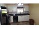 Bright kitchen with black appliances, white cabinetry, tile backsplash and stone countertops at 2101 Fox Chase Blvd # 102, Palm Harbor, FL 34683