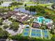 Aerial view featuring a luxurious community with a pool, tennis courts, and scenic lakes at 2112 Acadia Greens Dr # 62, Sun City Center, FL 33573
