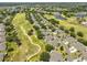 Aerial view of a community with homes, golf course, and lakes at 2112 Acadia Greens Dr # 62, Sun City Center, FL 33573