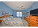 Well-lit bedroom featuring a plush bed, wood dresser, and a ceiling fan at 2112 Acadia Greens Dr # 62, Sun City Center, FL 33573