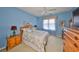 Comfortable bedroom with blue walls, a ceiling fan, wood furniture, and a large window at 2112 Acadia Greens Dr # 62, Sun City Center, FL 33573