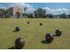 Expansive bowling green with players in the distance and scattered bowling balls at 2112 Acadia Greens Dr # 62, Sun City Center, FL 33573