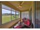 Bright sunroom with wicker furniture and red cushions, overlooking a serene golf course, perfect for relaxation and enjoyment at 2112 Acadia Greens Dr # 62, Sun City Center, FL 33573
