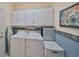 Practical laundry room equipped with a washer, dryer, and ample storage cabinets at 2112 Acadia Greens Dr # 62, Sun City Center, FL 33573