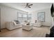 Open living room with a white couch, many windows, and a ceiling fan at 2125 Acorn S Pl, St Petersburg, FL 33712