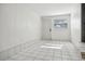 Bright room with white paneled walls, tiled floors, a window, and a white door at 2125 Acorn S Pl, St Petersburg, FL 33712